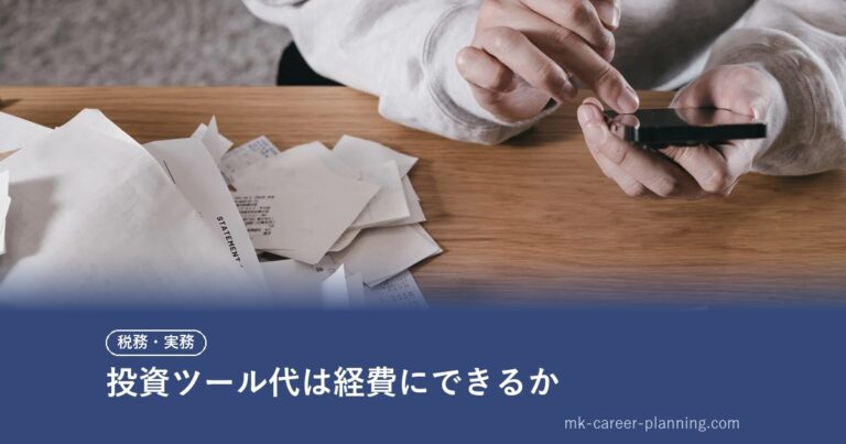 山積みの紙の領収書をスマートフォンで読み取り電子化する手元